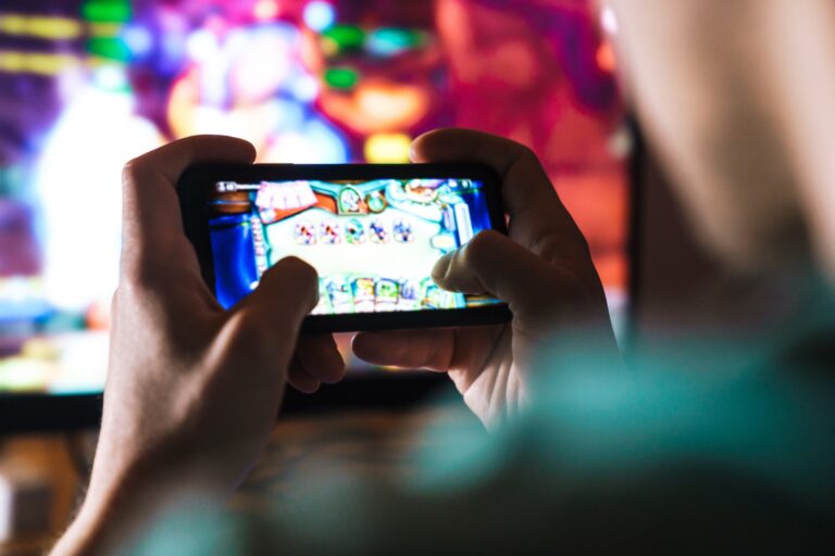 A person playing a casino game on their phone in the casino